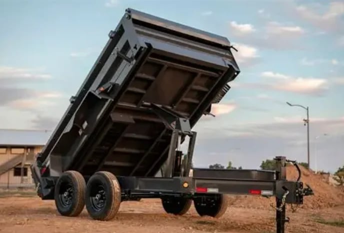 Black dump truck with raised bed on dirt road construction site